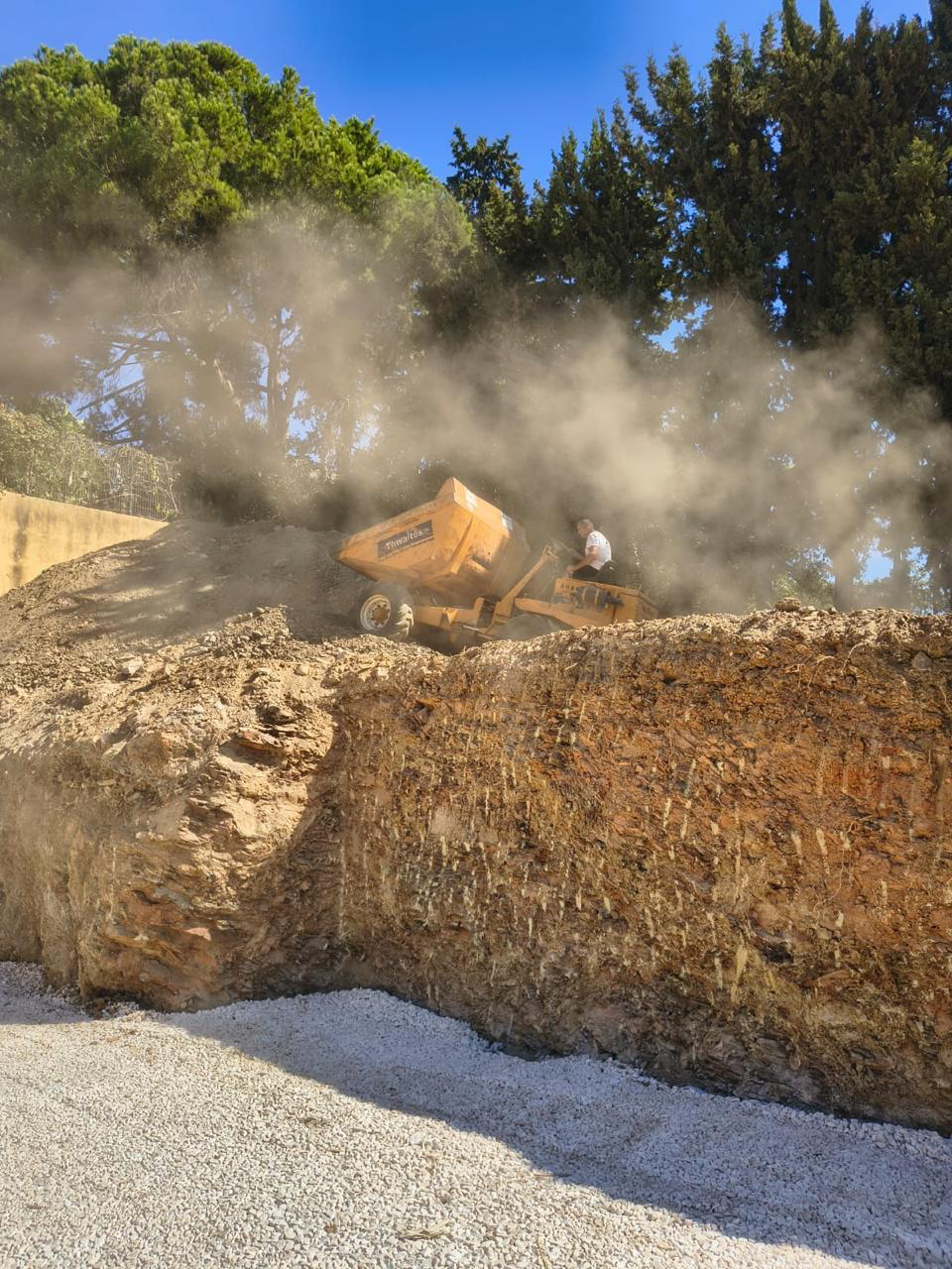 Earthworks at the El Rosario new build — dumper moving material against the cut embankment