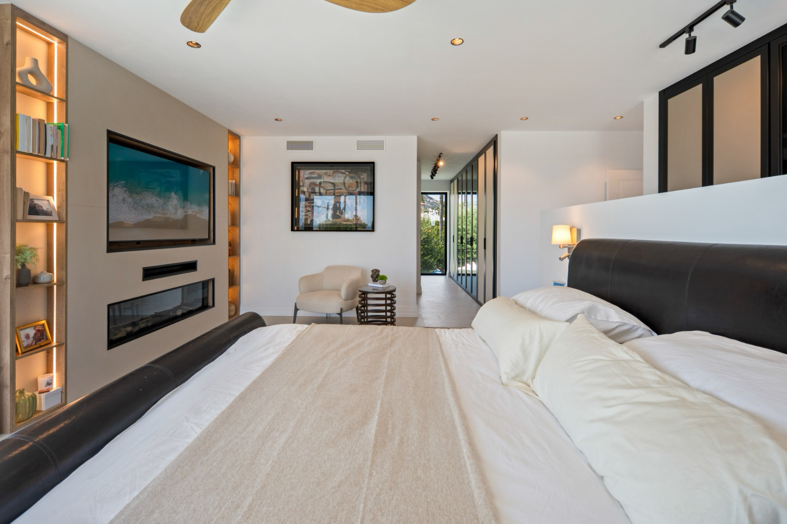 Master bedroom with leather headboard, fireplace and oak joinery