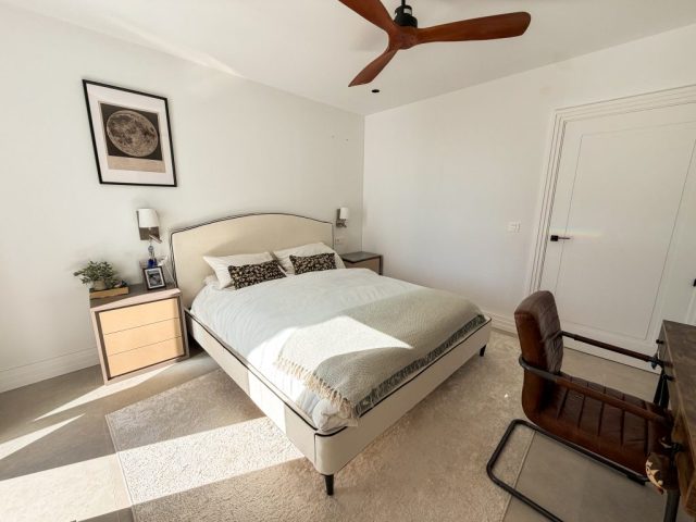 Guest bedroom with polished concrete floor and framed artwork