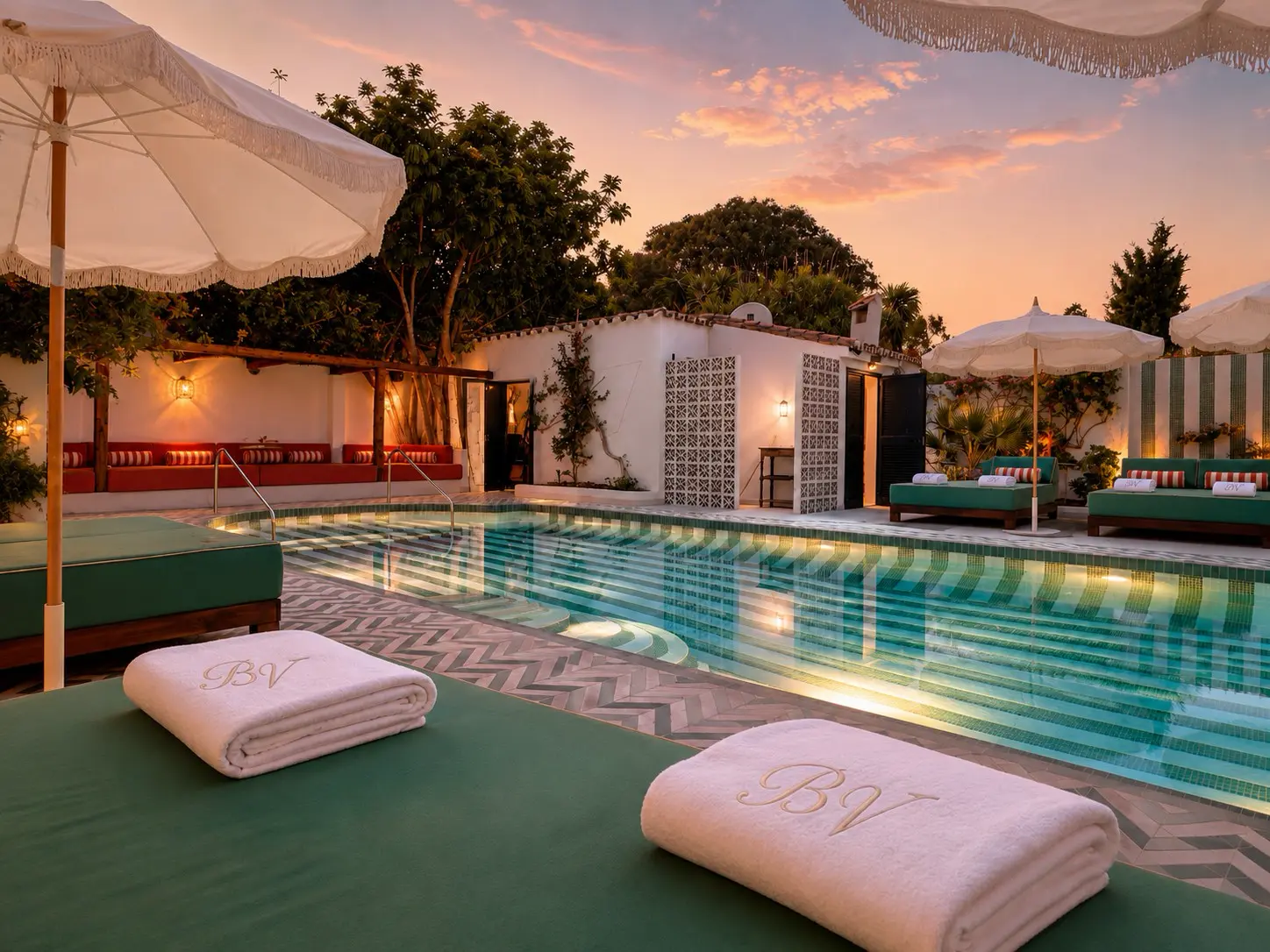 Boutique hotel courtyard swimming pool and furnished terrace at sunset
