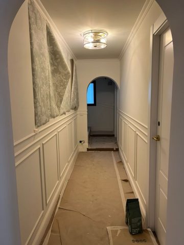 Hotel corridor receiving decorative wall panelling and lighting