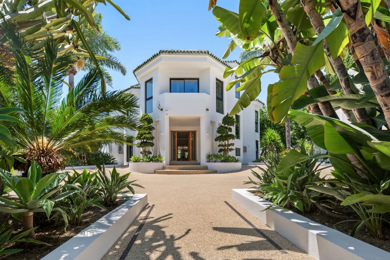 Landscaped entrance path leading to the villa's oak front door