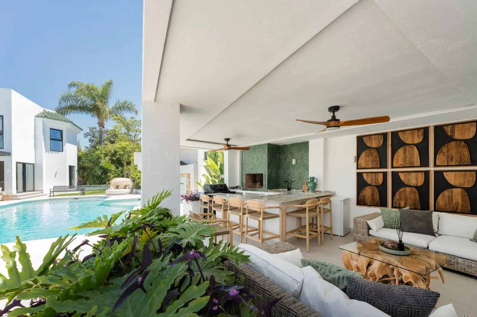 Covered outdoor kitchen and lounge overlooking the pool