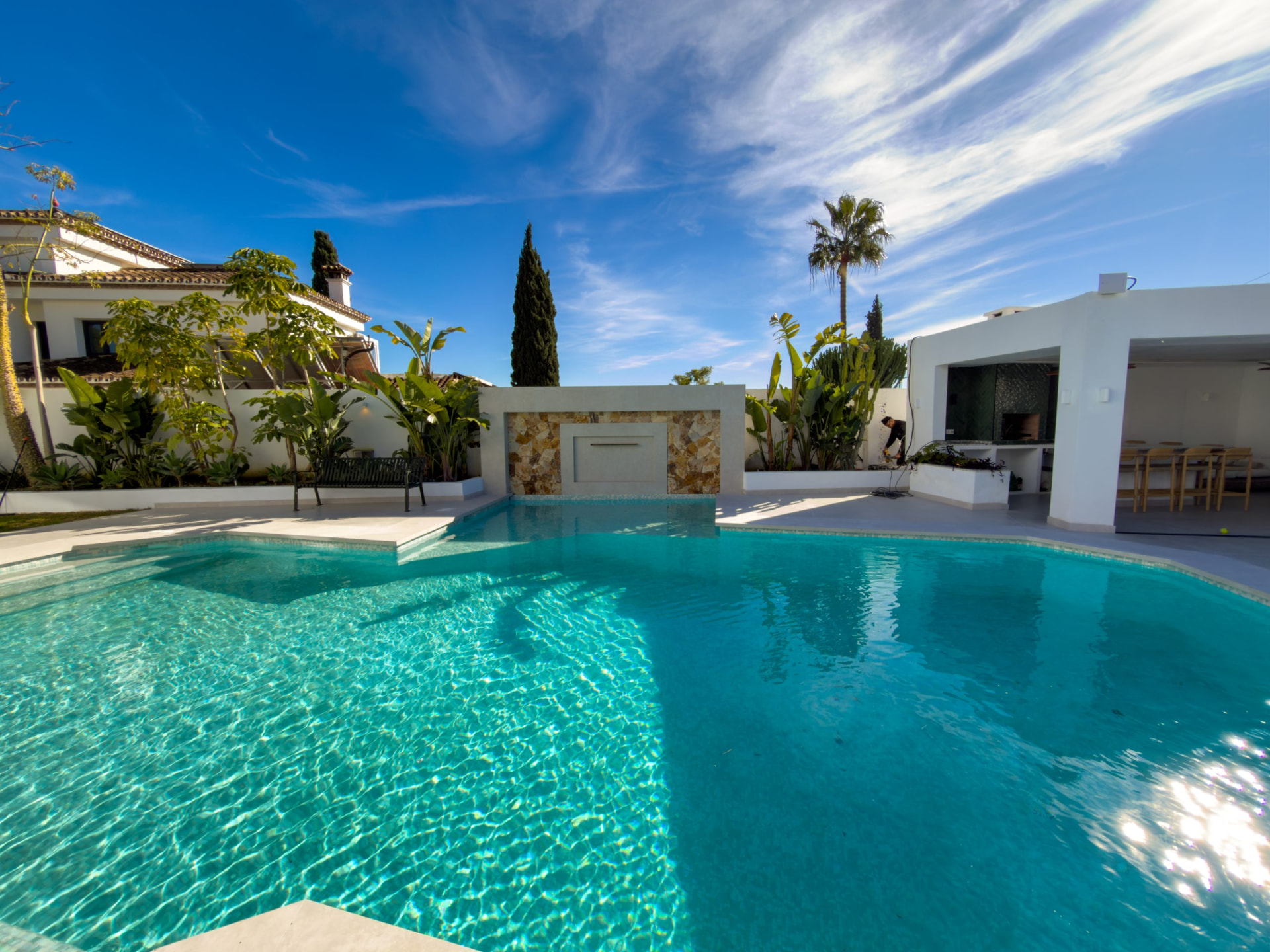 Pool with stone water feature and outdoor kitchen