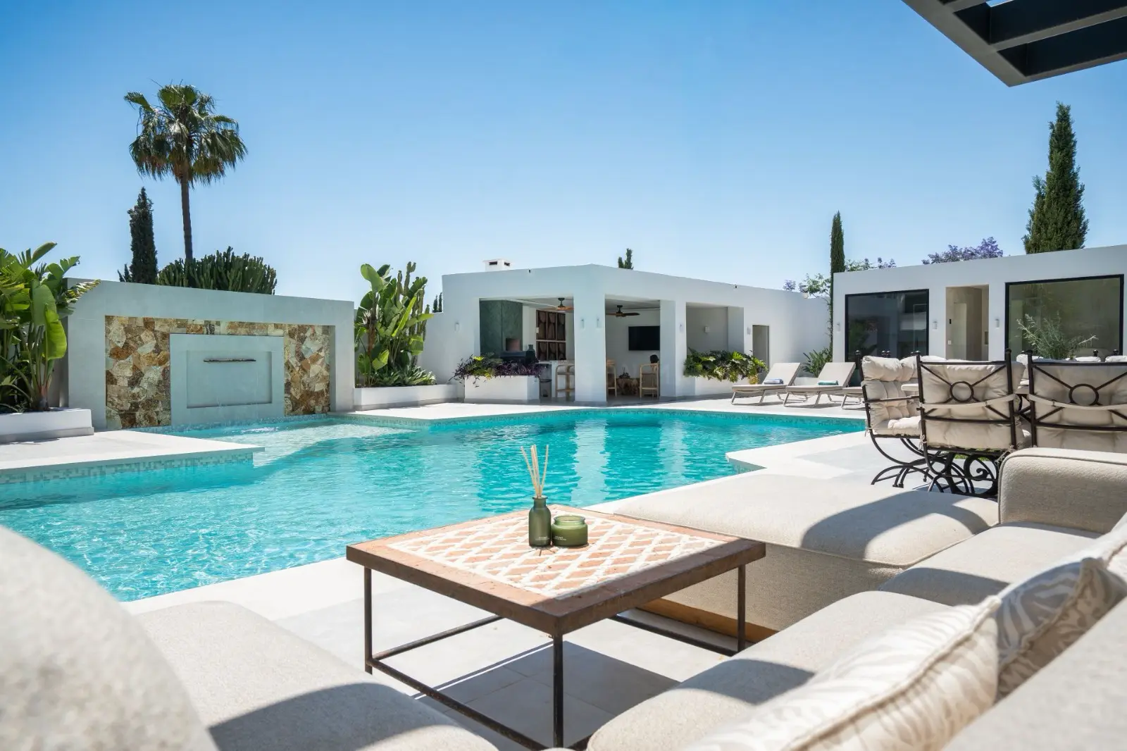 Poolside lounge with stone water feature and shaded seating
